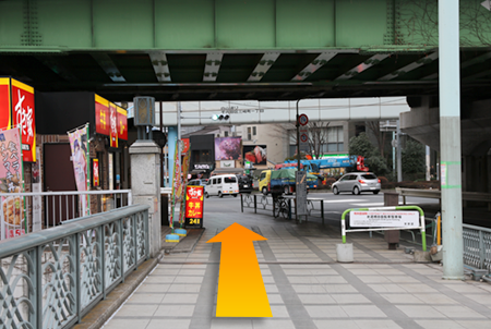 Walk under the train tracks and cross the pedestrian crossing ahead.